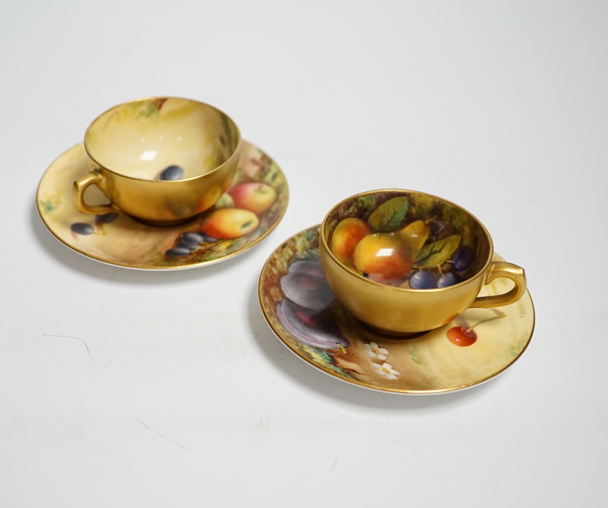 A pair of Royal Worcester fruit painted miniature cabinet cups and saucers, signed F. Harper and W.H. Austin